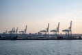 Blue freight cranes at the Port of Aarhus, Denmark during sunset, rear view from the distance