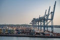 Blue freight cranes at the Port of Aarhus, Denmark during sunset, side view with lots of freight containers