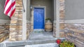 Blue front door and American flag on wall of home Royalty Free Stock Photo