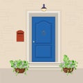 Blue front door with a mailbox on the wall and flowers in the po