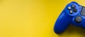 Blue gamepad on a bright yellow background.