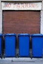 Blue garbage bins parked in a no parking zone