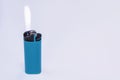 Blue gas lighter burning with fire on a light background Royalty Free Stock Photo