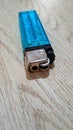 Blue gas lighter was lying on the table. Royalty Free Stock Photo
