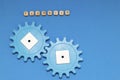 Blue gears on a blue background, the inscription teamwork. Interaction concept. The photo