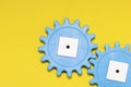 Blue gears on a yellow background, copy space. Interaction concept. The photo