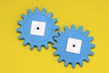 Blue gears on a yellow background, copy space. Interaction concept. The photo