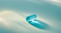 Blue gel capsule resting on a textured aqua surface under soft lighting Royalty Free Stock Photo
