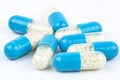 Blue gelatin capsules with white granules inside, isolated on a white background, macro shot. Royalty Free Stock Photo