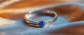 Blue Gemstone Ring on Golden Satin - Elegance and Simplicity. Concept Jewelry Photography, Blue