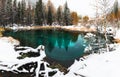 Blue geyser lake in autumn forest during snowfall. Altai, Siberia, Russia Royalty Free Stock Photo