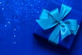 Blue gift box with aque mint bow on trendy blue background