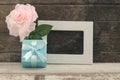 Blue gift box with blank frame and oink rose