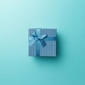 Blue gift box with blue ribbon on blue background. Top view. Flat lay. Copy space. Colorful background. Minimal christmas new year Royalty Free Stock Photo