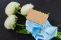 Blue gift box, bouquet of white flowers and empty tag. Mockup of greeting card for Father`s or Grandfather`s Day. Royalty Free Stock Photo