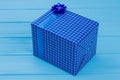Blue gift box with bow and blue wood. Royalty Free Stock Photo