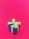 Blue gift box on fuchsia background. vertical . Royalty Free Stock Photo