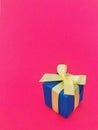 Blue gift box on fuchsia background. vertical, copy space. Royalty Free Stock Photo