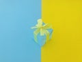 A blue gift box on half yellow and half blue background.