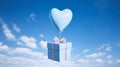 Blue gift box with pink ribbon bow and blue heart shaped balloon flying in the air on blue sky, Valentine s day background. Royalty Free Stock Photo