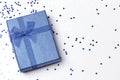 Blue gift box surrounded by purpunine and stars.