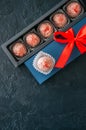 Blue gift box with red tape and chocolate on a black stone background Royalty Free Stock Photo