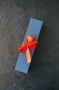 Blue gift box with red tape and chocolate on a black stone background Royalty Free Stock Photo