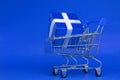 Blue gift box in shooing cart on blue background object , Resource for Christmas New Year`s Day Birthday Lucky draw and Shopping c Royalty Free Stock Photo