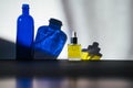 Blue glass bottle and face oil with shadows Royalty Free Stock Photo