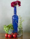 Blue glass bottle, vegetables and flowers Royalty Free Stock Photo