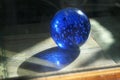 Blue glass crystal ball with bubbles. Magic sphere with light shing through the ball globe. Royalty Free Stock Photo