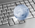 Blue glass globe on keyboard Royalty Free Stock Photo