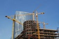 Blue glass high rise tower with a crane