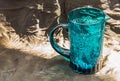 A blue glass jug and surface reflections on a black background Royalty Free Stock Photo