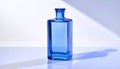 Blue Glass Perfume Bottle Filled with Liquid on a White Surface with Shadows image photo Royalty Free Stock Photo