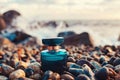 A blue glass perfume bottle on a wet pebble beach. In the background, the sea surf. Copy space. Close-up. Perfume Royalty Free Stock Photo