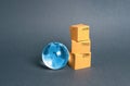 Blue glass planet globe and a stack of cardboard boxes. The concept of commerce and trade, cargo delivery, exchange of goods