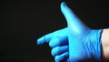 A blue gloved hand gives a thumbs up