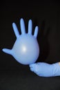 Blue gloved hand, holding a filled syringe, squirting down Royalty Free Stock Photo