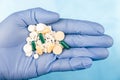 Blue-gloved hand pulls a handful of pills Royalty Free Stock Photo