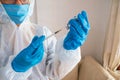 Blue gloved hands and syringe administering medicine in hospital