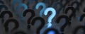 Blue glowing question mark on right side with other questions, on dark background Royalty Free Stock Photo