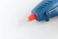 Blue glue gun and hot melt rods on white background Royalty Free Stock Photo