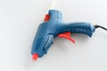 Blue glue gun and hot melt rods on white background Royalty Free Stock Photo