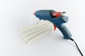 Blue glue gun and hot melt rods on white background Royalty Free Stock Photo