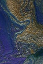 Blue and gold abstract makeup background.Shimmer backdrop.Beautiful stains of liquid nail laquers.Fluid art,pour painting