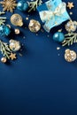 Blue and gold luxury Christmas balls ornaments, glitter blue paper gift box, fir branches on dark blue background. Xmas vertical Royalty Free Stock Photo