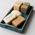Blue and gold tray containing rectangular and square soaps. Two rectangular soaps, embossed with Royalty Free Stock Photo
