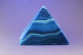 Blue granite crystal pyramid on a purple background