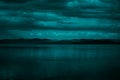 Blue green clouds over the sea. Toned seascape. Dark teal water and sky background with copy space for design. Royalty Free Stock Photo